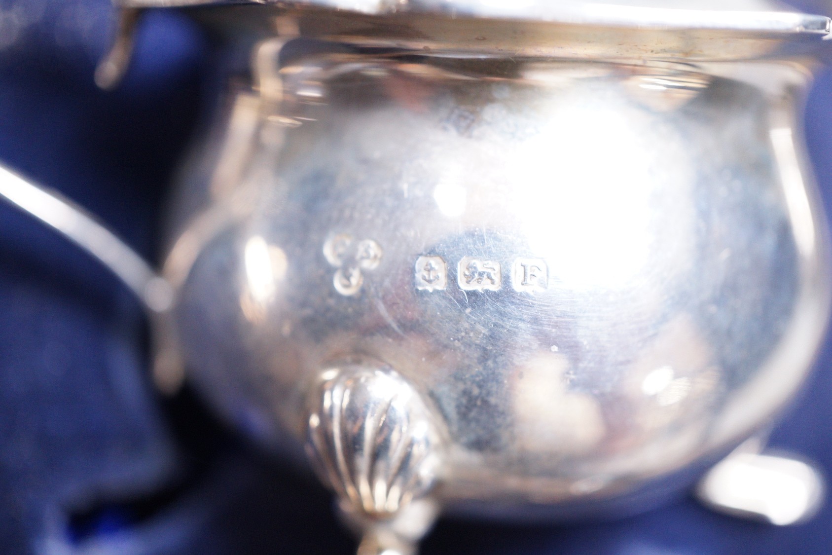 A cased George V silver three piece condiment set, two other silver condiments and a plated condiment.